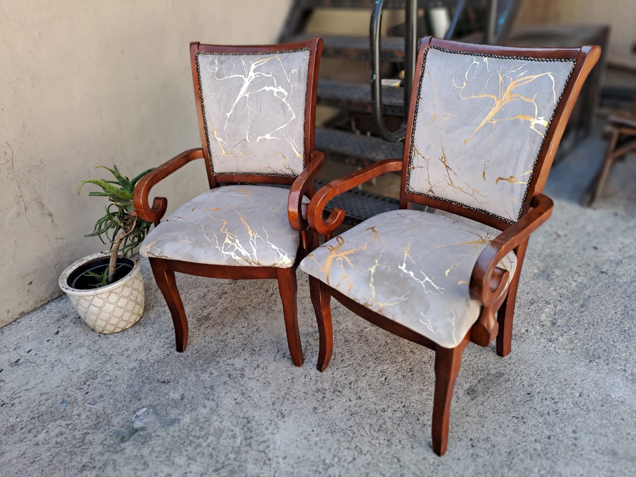 Pair of wooden carver chairs with marble-print fabric