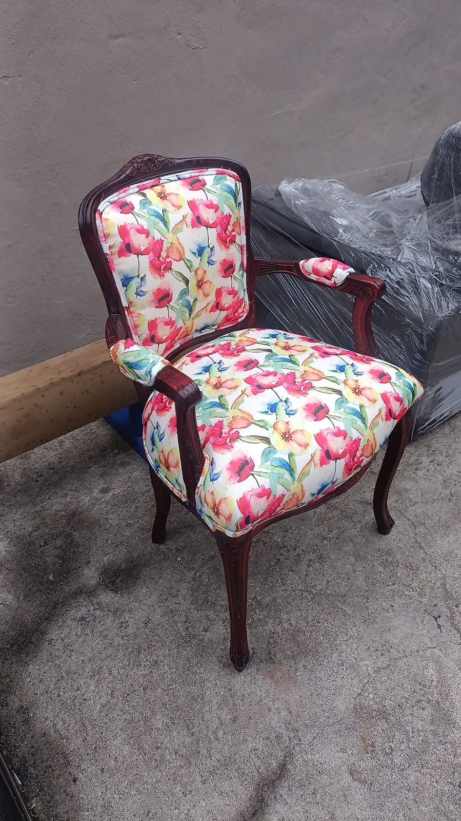 Antique carved armchair in floral fabric
